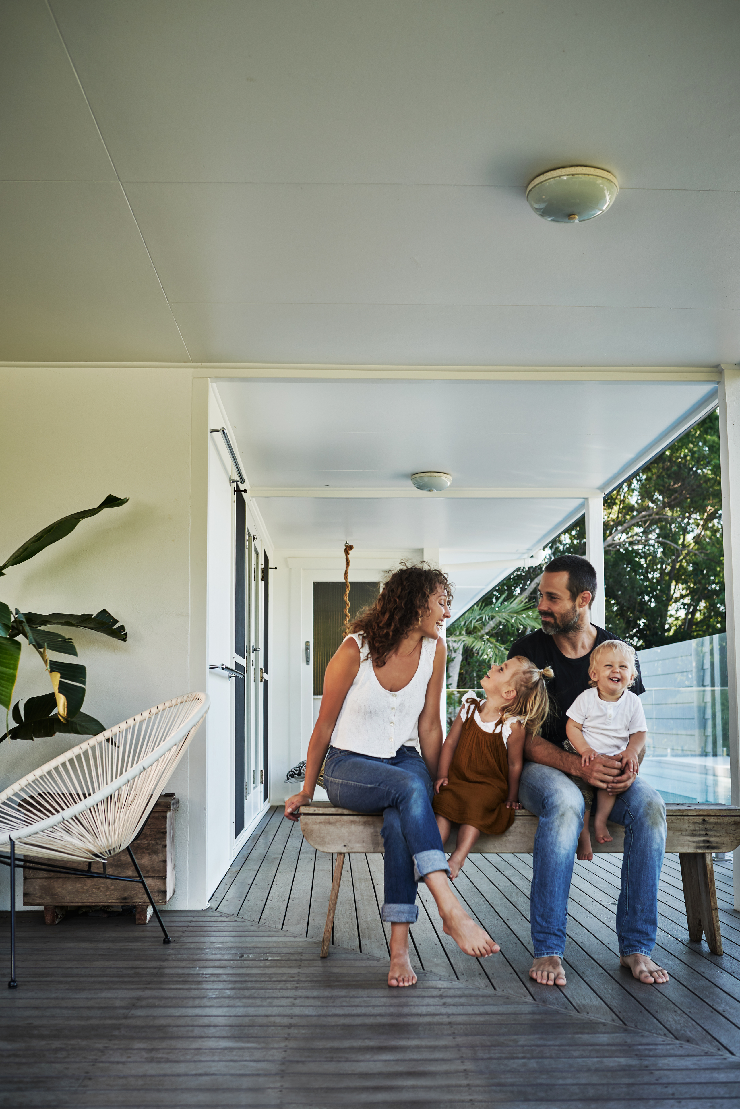A family enjoying time together on a porch, accompanied by their dog, creating a warm and inviting atmosphere.